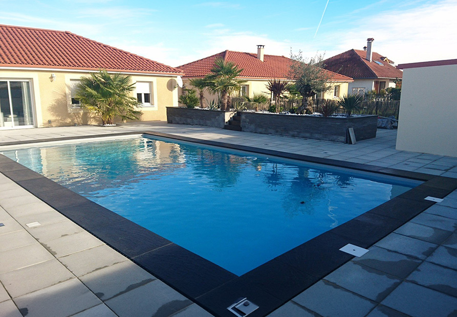 Piscine traditionnelle à Pau avec dallage extérieur et margelles par SARL DSR Construction